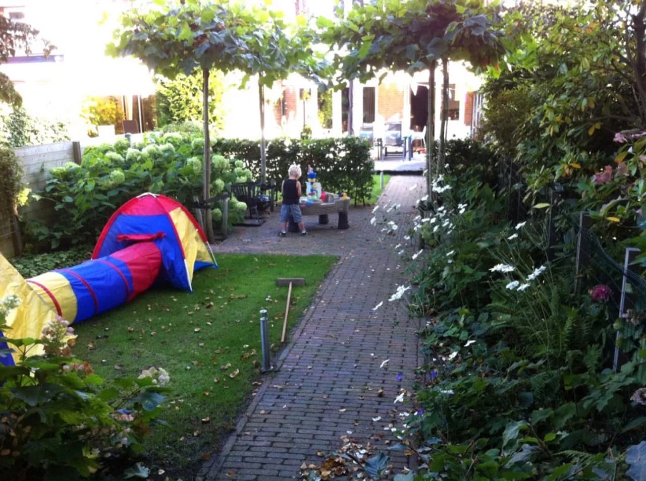 Schommelen naast de klimhut in deze bloeiende tuin in Wassenaar. Het is heerlijk spelen onder de verkoelende schaduw van de bomen in de tuin in Wassenaar