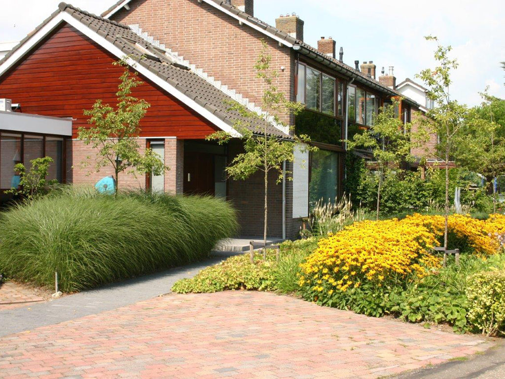 Overzicht van een strak vormgegeven weelderige voortuin aan de Rotte